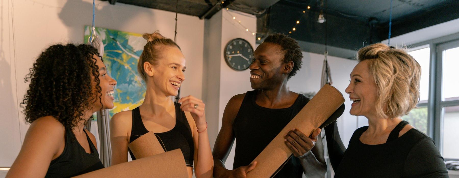a group of people holding yoga mats