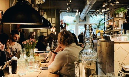 people sitting at tables in a restaurant