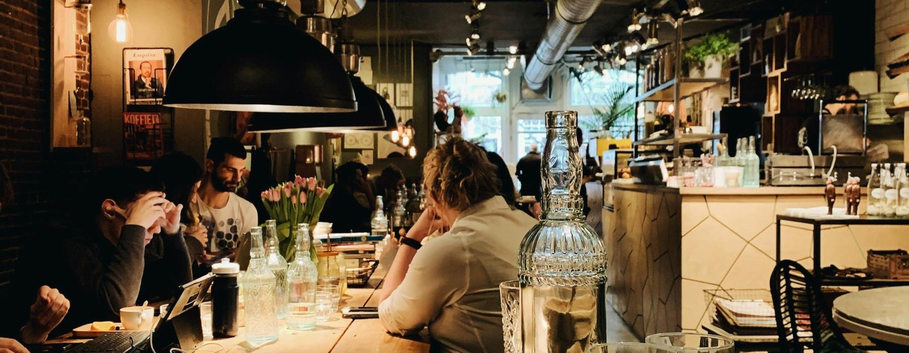 people sitting at tables in a restaurant