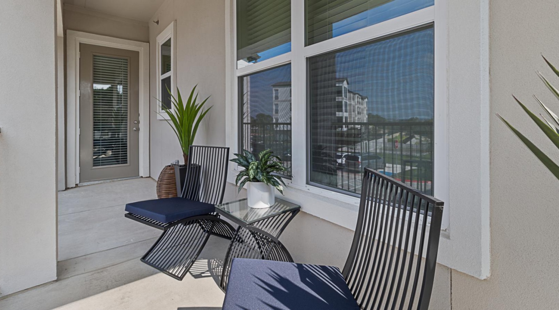 a patio with a table chairs and a window with blinds