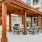 a covered patio with seating and a fireplace