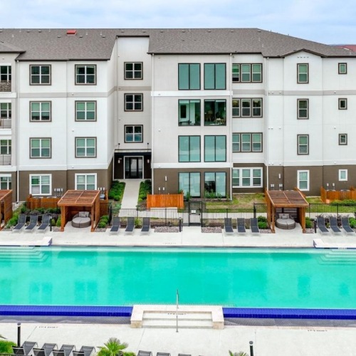 Relax and unwind poolside a pool in front of a building