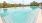 a swimming pool with trees in the background