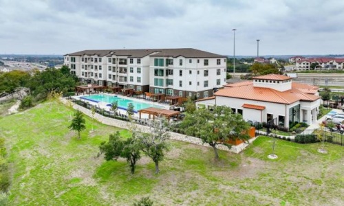a building with a lot of windows and pool in front