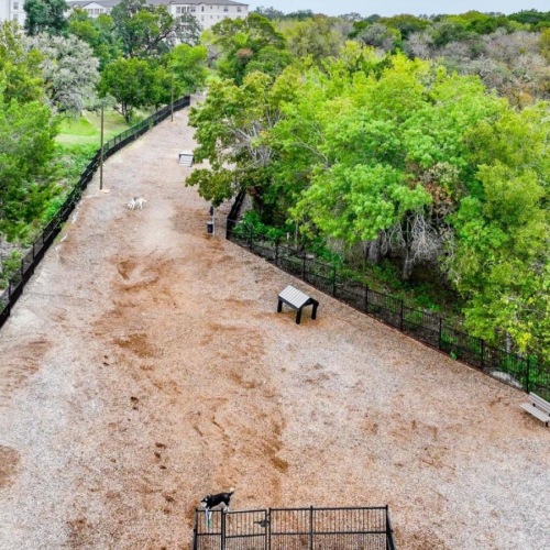 Reveal at Onion Creek is a pet-friendly community! a dirt field with trees and buildings
