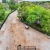 a dirt field with trees and buildings